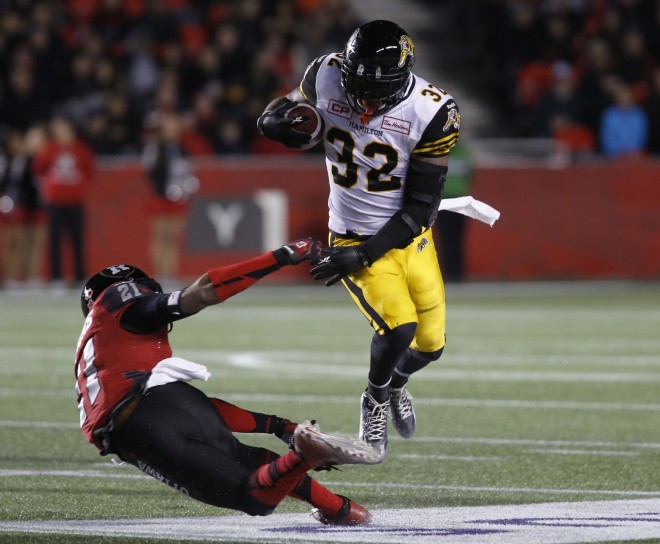 The Hamilton Tiger-Cats C.J. Gable avoids a tackle by the Ottawa Redblacks Brandon Sermons during fourth quarter CFL action in Ottawa on Saturday, November 7, 2015.  (CFL PHOTO - Patrick Doyle)