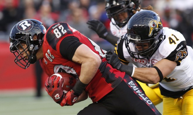 The Ottawa Redblacks Greg Ellingson is tackled by the Hamilton Tiger-Cats Erik Harris during first quarter CFL action in Ottawa on Saturday, November 7, 2015.  (CFL PHOTO - Patrick Doyle)