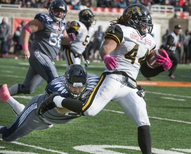 Hamilton Tiger-Cats Taylor Reed outruns Montreal Alouettes  defence as he carries the ball during 2nd half CFL action in Montreal on Sunday October 18, 2015 (CFL PHOTO - Peter McCabe)