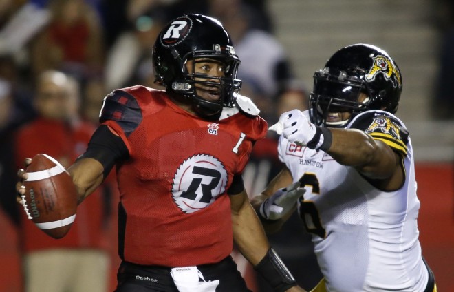 The Ottawa Redblacks quarterback Henry Burris avoids a tackle by the Hamilton Tiger-Cats Bryan Hall during second quarter CFL action in Ottawa on Saturday, November 7, 2015.  (CFL PHOTO - Patrick Doyle)