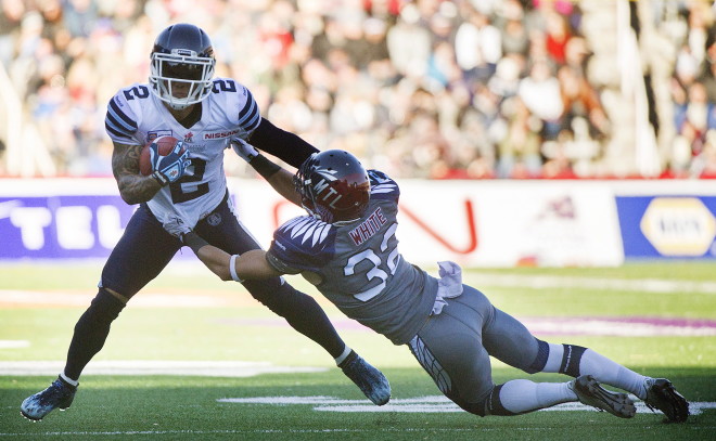 Toronto Argonauts' Chad Owens, left, is tackled by Montreal Alouettes' Mitchell White during second half CFL football action in Montreal, Sunday, November 2, 2014. THE CANADIAN PRESS/Graham Hughes