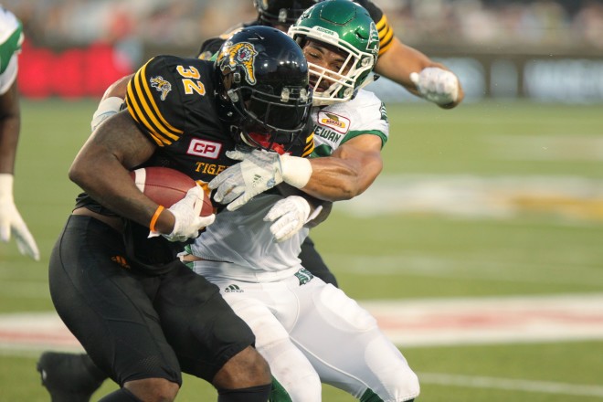 Ticats'  C.J. Gable is tackled by Roughriders' Korey Jones during Second quarter CFL action in Hamilton on Saturday, August 20th, 2016.  (CFL PHOTO - Dave Chidley)
